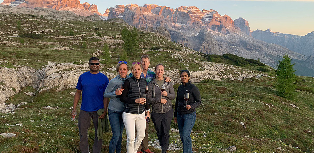 Group enjoys wine with the Dolomites in the background on Dolomites Multi-Sport Adventure